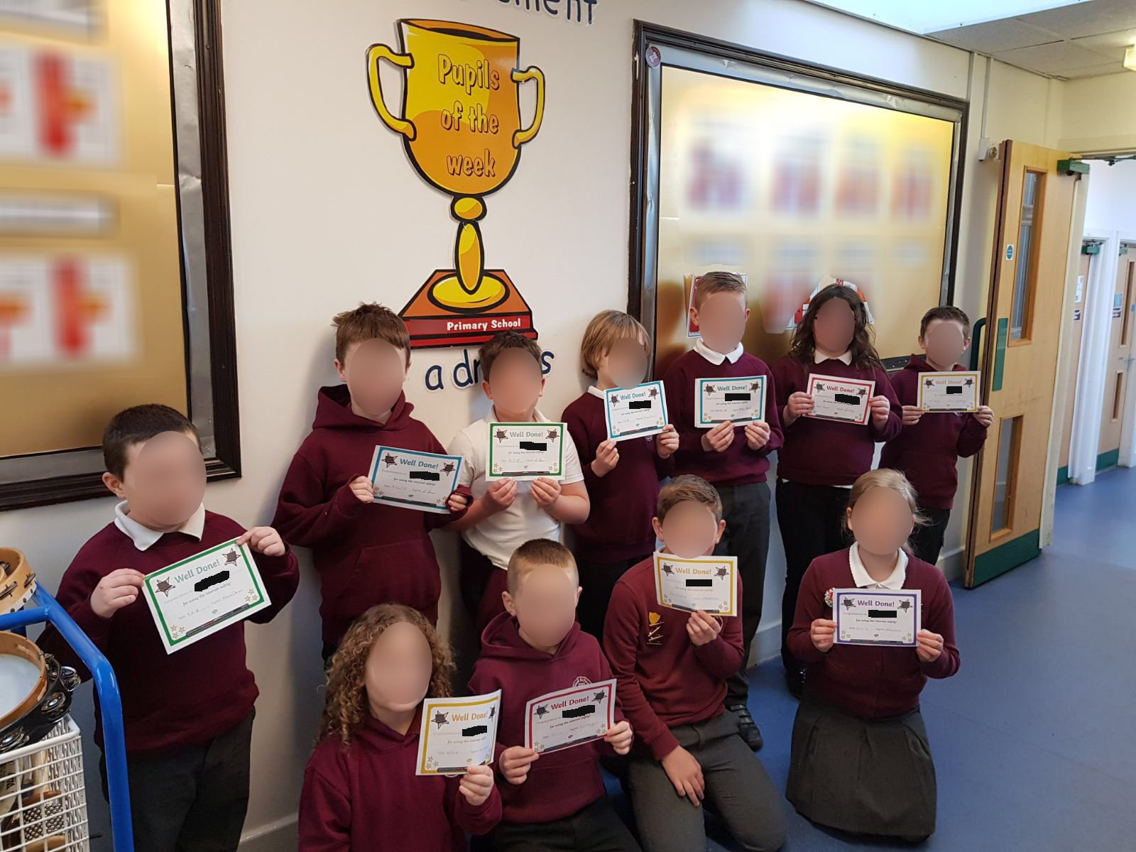 A class of school children holding up certificates for using the internet safely